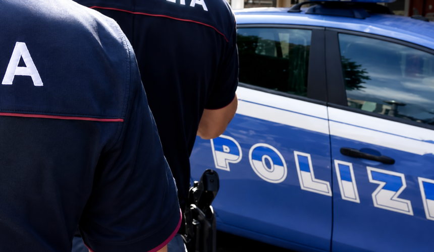 Due agenti della Polizia di Stato vicino a una volante blu durante un servizio di controllo e sicurezza urbana.