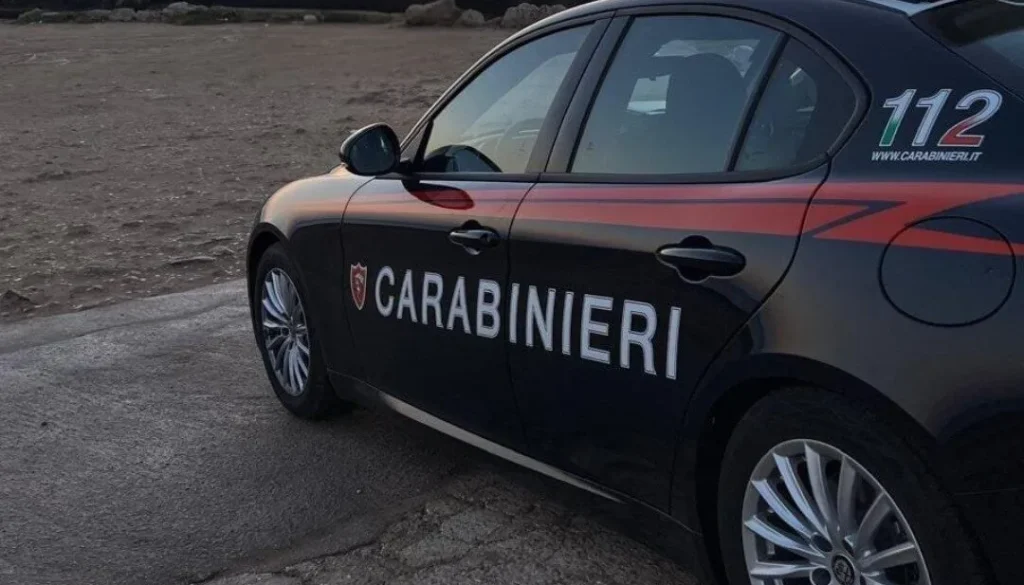 Auto dei Carabinieri nera con scritta bianca laterale “Carabinieri”, fotografata in una zona esterna al tramonto.