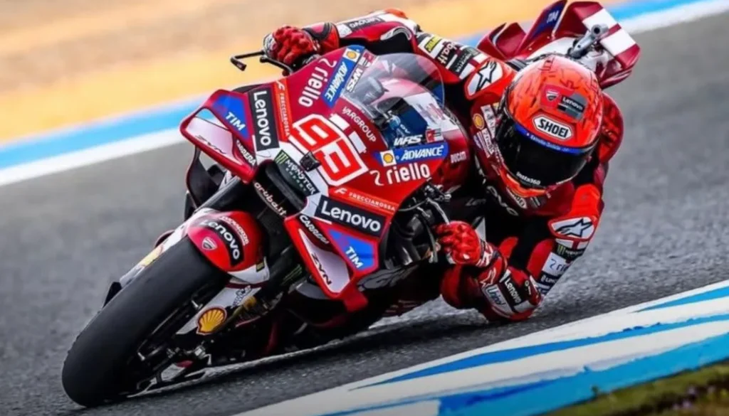 Pilota Ducati del campionato MotoGP affronta una curva del circuito con una piega molto accentuata vicino all’asfalto.