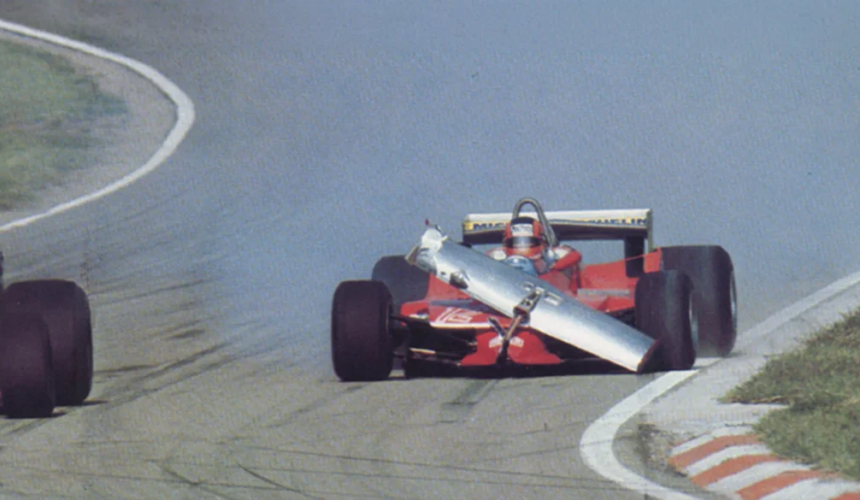 Auto Ferrari di Formula 1 percorre il circuito con una parte dell’alettone anteriore danneggiata e sollevata davanti alla vettura.