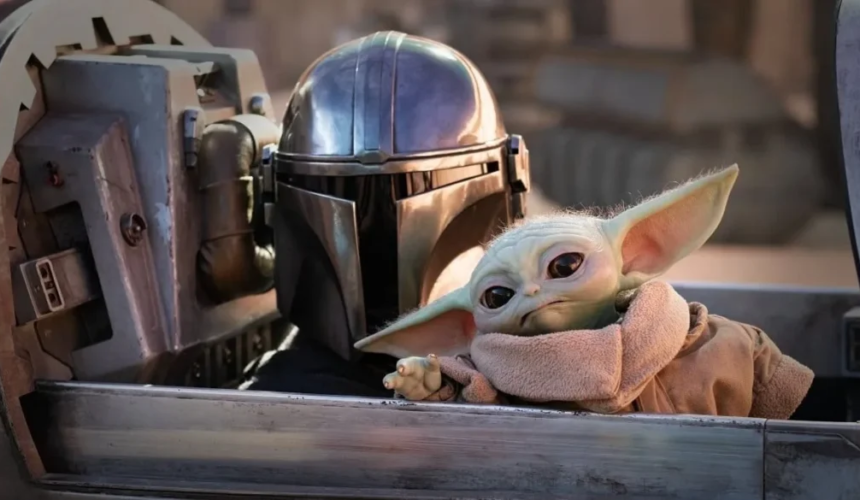 Grogu seduto accanto al Mandaloriano all’interno di una navicella nella serie The Mandalorian.
