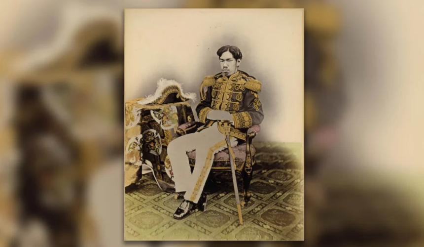 Ritratto storico dell’Imperatore Meiji seduto in uniforme militare decorata con una sciabola accanto a sé.