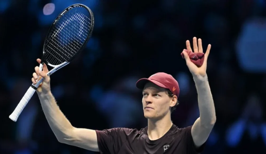 Il tennista Jannik Sinner alza la racchetta e saluta il pubblico durante un match indoor a Torino.