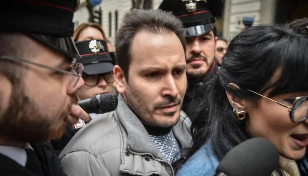 Andrea Sempio tra giornalisti, microfoni e carabinieri durante un momento legato alle indagini sul caso Garlasco.