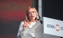 Donna interviene a un convegno parlando dal podio con microfoni.