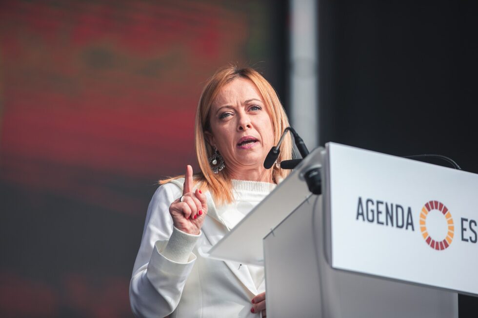 Donna interviene a un convegno parlando dal podio con microfoni.