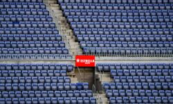 Tribune vuote di uno stadio con cartello
